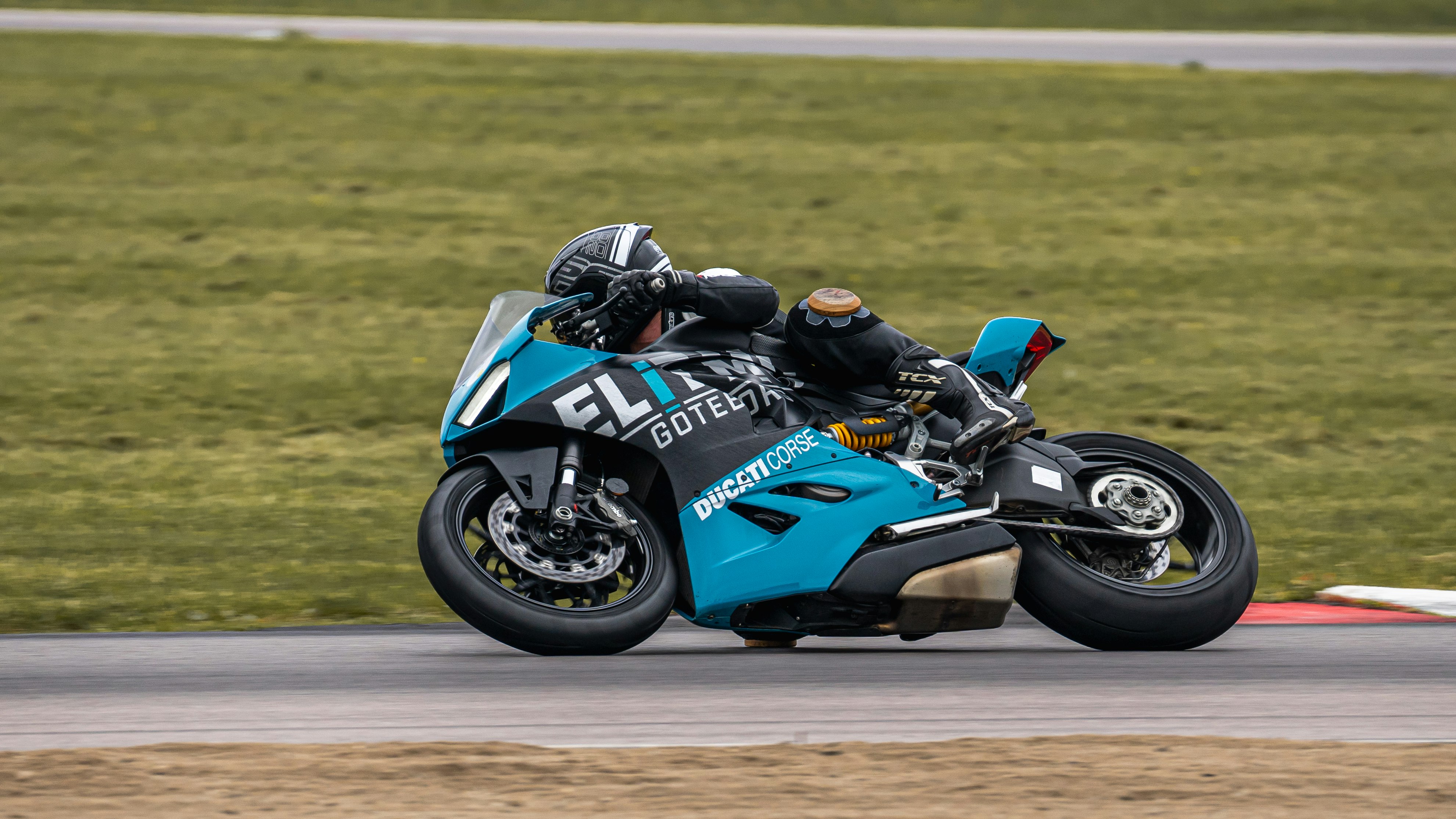 man riding blue and black sports bike on brown field during daytime